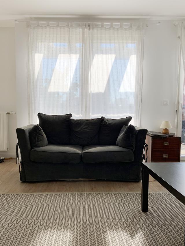 Salon avec canapé et table basse noirs pour plus de modernité.