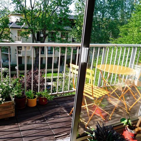 Balcon fleuri avec table et chaises de jardin pour prendre un verre au soleil