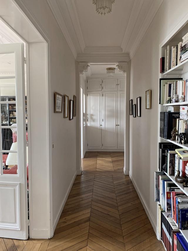 Couloir menant aux chambres rythmé par des étagères et des tableaux Couloir menant aux chambres rythmé par des étagères et des tableaux