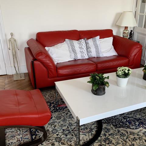 Salon avec canapé rouge et table blanche Roche Bobois