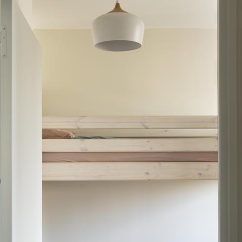 Chambre enfants avec lit superposé et luminaire design.