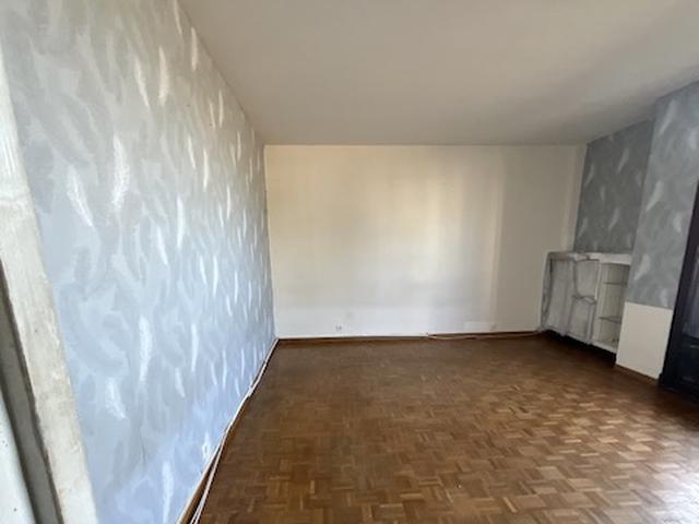 Avant, le salon daté avec son parquet sombre et abîmé.