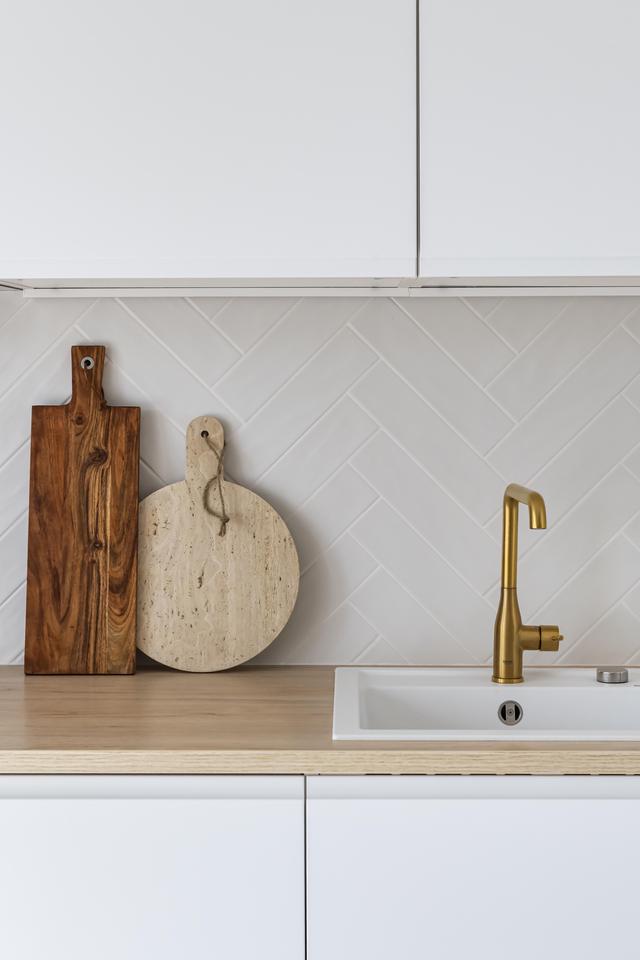 Carrelage blanc façon Zellige posé en chevron pour plus d’élégance à cette crédence.