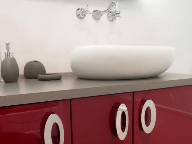 Meuble de salle de bain rouge avec lavabo galet et robinetterie encastrée. Meuble de salle de bain rouge avec lavabo galet et robinetterie encastrée.