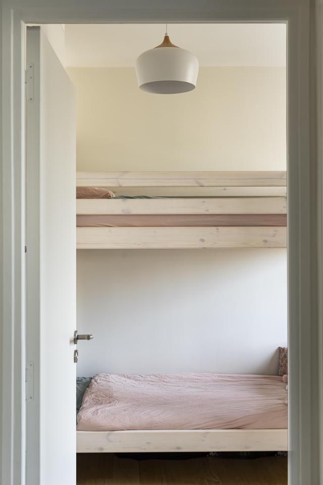 Chambre enfants avec lit superposé et luminaire design.