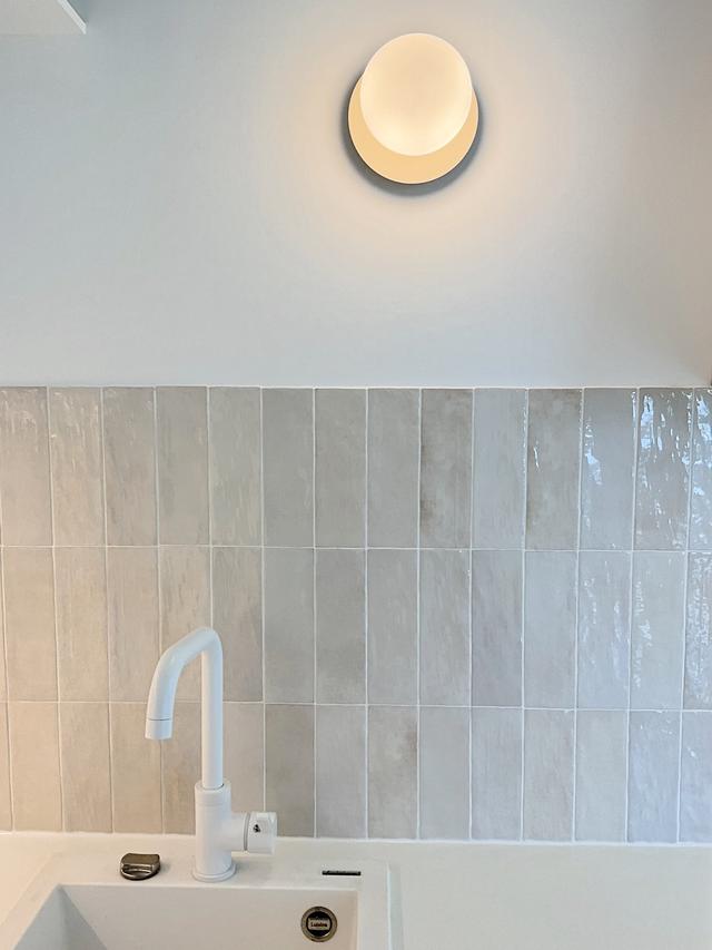 Détail cuisine avec zellige beige rosé et applique laiton.