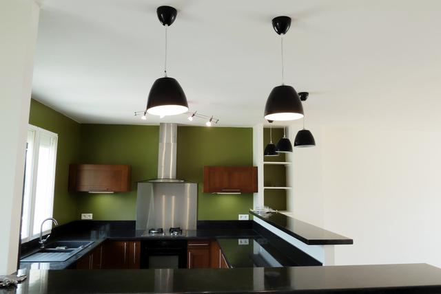 La cuisine est ouverte sur le séjour tout en étant délimitée par 2 comptoirs en quartz noir
