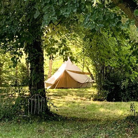 Une grande tente installée au fond du jardin fait office de cabane pour le plus grand plaisir des enfants