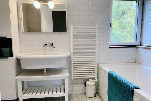 Salle de bain enfants avec carrelage métro blanc aux murs et façon parquet vieilli bleu au sol